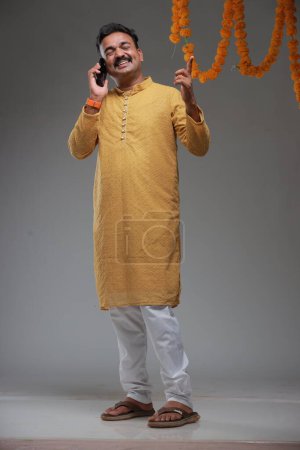 Photo for A man with Indian traditional costume, with plain background, isolated, wearing yellow kurta and white pyjama. - Royalty Free Image