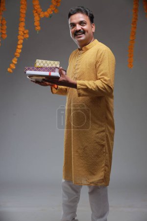 Photo for A man with Indian traditional costume, with plain background, isolated, wearing yellow kurta and white pyjama. - Royalty Free Image