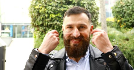Téléchargez les photos : Homme barbu frisant sa moustache en plein air et le déplaçant drôle. - en image libre de droit