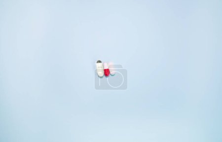 Foto de Spilled medications and pills on a blue background. Pharmacology and medicine struggle for health. - Imagen libre de derechos