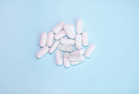 Téléchargez les photos : Spilled medications and pills on a blue background. Pharmacology and medicine struggle for health. - en image libre de droit
