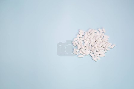 Foto de Spilled medications and pills on a blue background. Pharmacology and medicine struggle for health. - Imagen libre de derechos