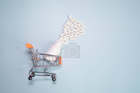 Téléchargez les photos : Shopping cart with pills and tablets on light background. - en image libre de droit