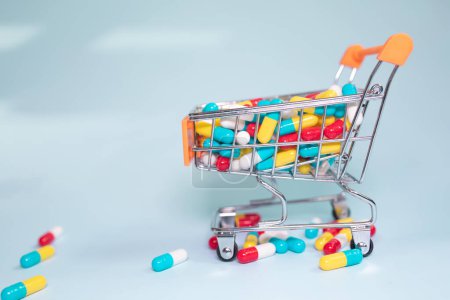 Photo for Shopping cart with pills and tablets on light background. - Royalty Free Image