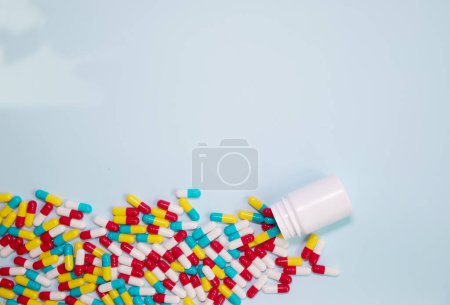 Foto de Medicine bottle and pills spilled on a light blue background. Medicines and prescription pills background - Imagen libre de derechos