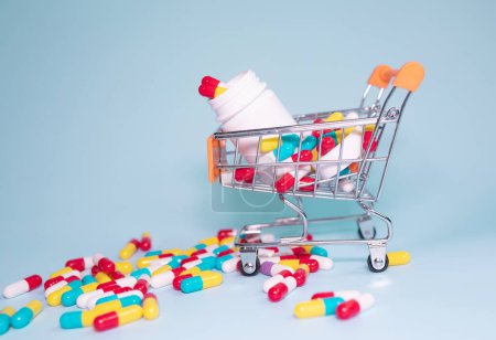 Téléchargez les photos : Shopping cart with pills and tablets on light background. - en image libre de droit