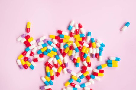 Foto de Pastillas, tabletas y cápsulas de medicina farmacéutica sobre fondo rosa. Concepto de medicina. - Imagen libre de derechos