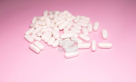 Téléchargez les photos : Pilules de médecine pharmaceutique, comprimés et capsules sur fond rose. Concept de médecine. - en image libre de droit