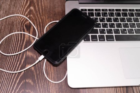 Photo for Plug in USB cord, cable charger, charging, charged and data transfer of the mobile phone, smartphone with a laptop - Royalty Free Image