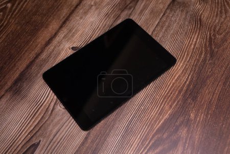 Photo for Digital tablet computer with blank screen on wooden background. - Royalty Free Image