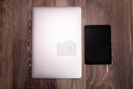 Téléchargez les photos : Ordinateur portable moderne et tablette numérique sur table en bois, vue sur le dessus - en image libre de droit
