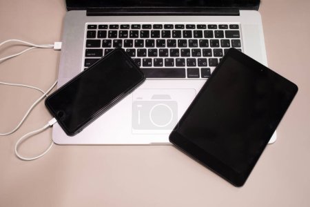 Téléchargez les photos : Smartphone se connectant à l'ordinateur portable et tablette PC - en image libre de droit