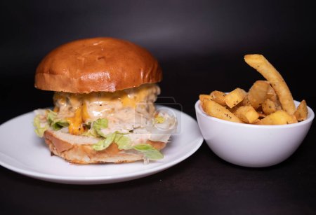 Photo for Fresh tasty burger and french fries on black table. - Royalty Free Image