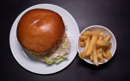 Photo for Fresh tasty burger and french fries on black table. - Royalty Free Image