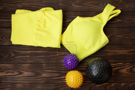 Photo for Massage balls and sport clothes on a wood table. - Royalty Free Image