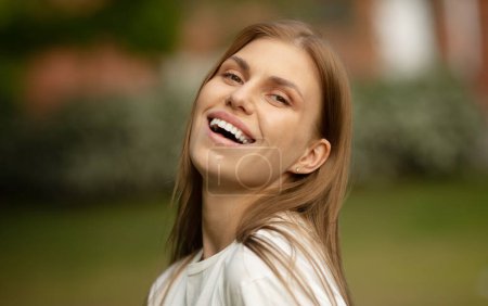 Foto de Retrato al aire libre de una hermosa joven alegre. Mujer feliz con el pelo largo excitado con sonrisa dentada. - Imagen libre de derechos