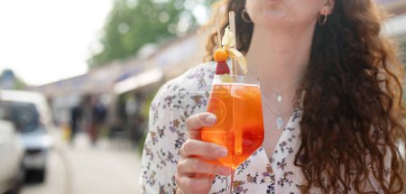 Photo for Woman enjoying day in outdoor cafe. Woman drinking iced summer cocktail - Royalty Free Image