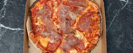 Téléchargez les photos : Pizza au fromage Mozzarella, jambon, poivre, viande, sauce tomate, épices et roquette fraîche. Pizza italienne fond. - en image libre de droit