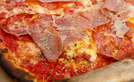 Foto de Pizza con queso Mozzarella, jamón, pimienta, carne, salsa de tomate, especias y rúcula fresca. Fondo de pizza italiana. - Imagen libre de derechos