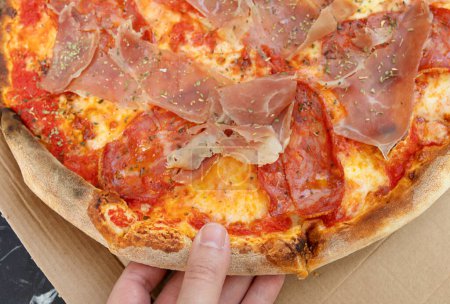 Foto de Primer plano vista de la persona tomando rebanada de queso sabrosa pizza fresca primer plano - Imagen libre de derechos
