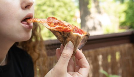 Foto de Hermosa joven comiendo deliciosa pizza. - Imagen libre de derechos