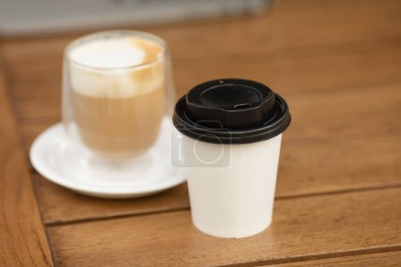 Photo for Two cups of coffee on rustic background. Paper cup of coffee and glass cup. Coffee to go. - Royalty Free Image