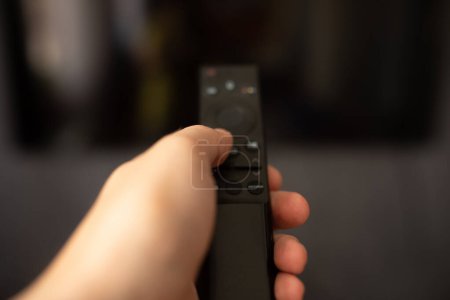 Foto de Vista de cerca del hombre utilizando el mando a distancia y viendo la televisión - Imagen libre de derechos