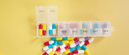 Téléchargez les photos : Différentes pilules et capsules sur fond jaune - en image libre de droit