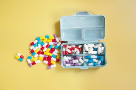 Téléchargez les photos : Pilules dans la boîte sur fond de couleur - en image libre de droit