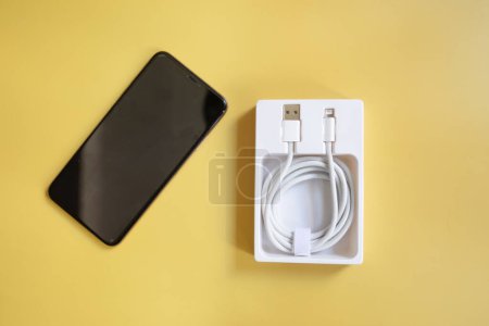 Photo for Charging smartphone and charger on yellow background - Royalty Free Image
