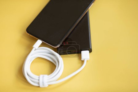 Photo for Power bank and mobile phone on yellow background. - Royalty Free Image