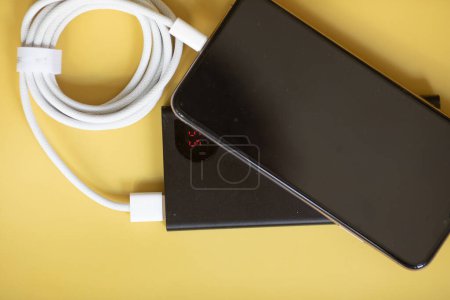 Photo for Charging power bank and smartphone on yellow background - Royalty Free Image