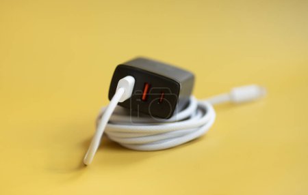 Foto de Enchufe USB y cable de alimentación sobre fondo amarillo. - Imagen libre de derechos