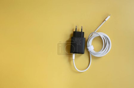 Téléchargez les photos : Câble d'alimentation pour charger sur fond jaune. - en image libre de droit