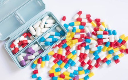 Téléchargez les photos : Différentes pilules en récipient sur fond blanc - en image libre de droit
