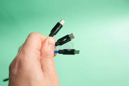 Téléchargez les photos : Câbles électriques avec fils et main sur fond vert. - en image libre de droit