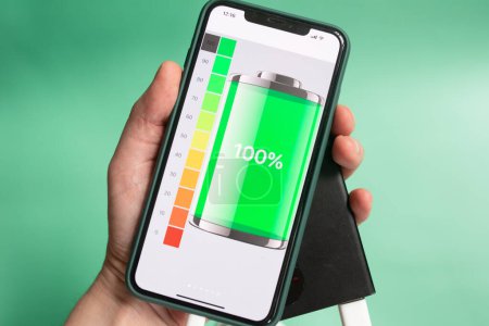 Téléchargez les photos : Chargeur portable rechargeant un smartphone isolé sur un fond vert. Banque de puissance. - en image libre de droit