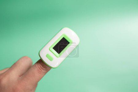 Photo for Pulse oximeter on finger showing oxygen saturation and heart rate. - Royalty Free Image