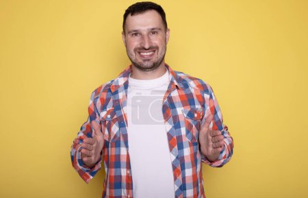Photo for Young man showing something over yellow background - Royalty Free Image