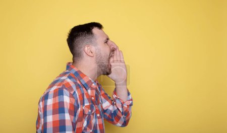 Photo for Handsome man covering his mouth and yelling - Royalty Free Image