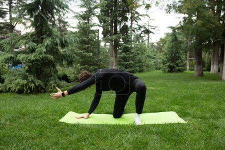 Foto de Hombre haciendo ejercicio al aire libre en el jardín entrenando en una esterilla de yoga. Ejercicio para la salud. Yoga. - Imagen libre de derechos