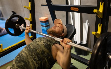 Photo for Man during bench press exercise with barbell in gym. - Royalty Free Image