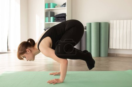 Téléchargez les photos : Jeune femme attrayante pratiquant le yoga à l'intérieur. Femme pratiquant dans un club de fitness. Concept de yoga. Mode de vie. - en image libre de droit