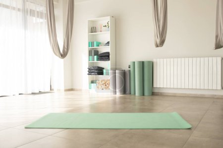 Téléchargez les photos : Salle de yoga avec tapis de yoga vert - en image libre de droit