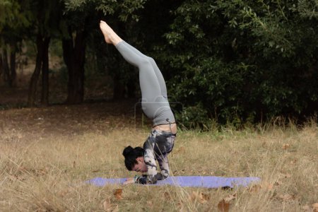 Téléchargez les photos : Portrait d'une jeune femme faisant du yoga dans la forêt pour une séance d'entraînement. Concept de fitness et mode de vie sain . - en image libre de droit