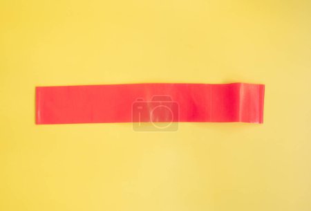 Photo for Top view of red rubber band for fitness on yellow background. Sports concept. Fitness trend. - Royalty Free Image