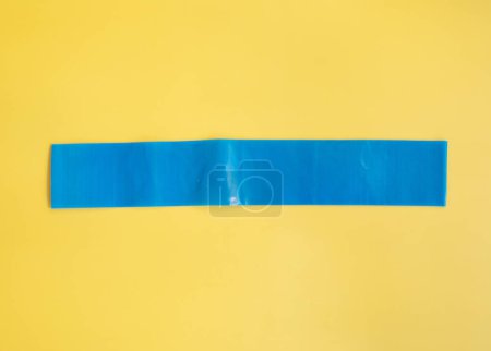 Photo for Top view of blue rubber band for fitness on yellow background. Sports concept. Fitness trend. - Royalty Free Image