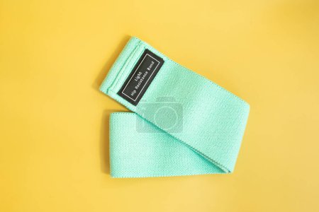 Photo for Top view of green rubber band for fitness on yellow background. Sports concept. Fitness trend. - Royalty Free Image
