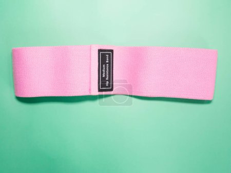 Photo for Pink hip resistance band for fitness on green background. sports concept. - Royalty Free Image
