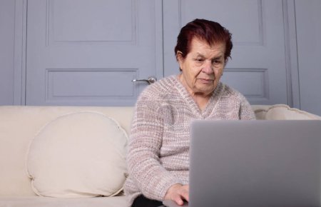 Photo for Portrait of elderly woman using computer at home office. Remote work concept. Senior woman buy on-line, spend free time on internet, enjoy communication in social media, resting at home. - Royalty Free Image